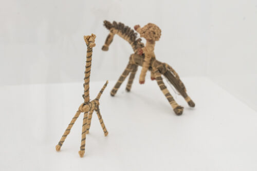 Else Mögelin, Spielzeuggiraffe und Spielzeugfigur Pferd mit Reiter, 1924, Bast, Ausstellungsansicht, Else Mögelin. Ich wollte, gegen alle Hindernisse, weben, BLMK Cottbus, 2023 © Nachlass Else Mögelin, Foto: Bernd Schönberger